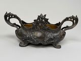 an antique silverplated bowl with floral decoration on a stand