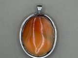 a close up of a pendant on a table with a white background