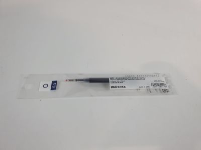 a close up of a pen sitting on top of a white table