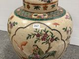 an image of a vase with a bird on it sitting on the ground