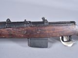 an old rifle with a wooden barrel on a white surface