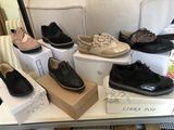 many pairs of shoes that are on display on a table