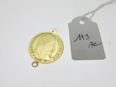 une pièce d'or à laquelle est attachée une étiquette