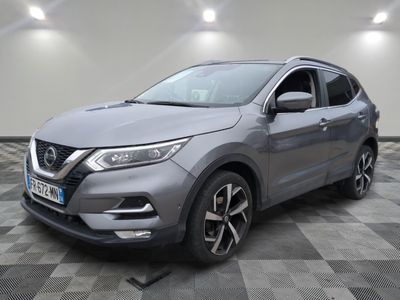 une Nissan QXV grise garée sur un sol à damier