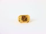 gros plan d'une bague en or sur une surface blanche
