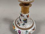 a white and gold vase with a bird on it