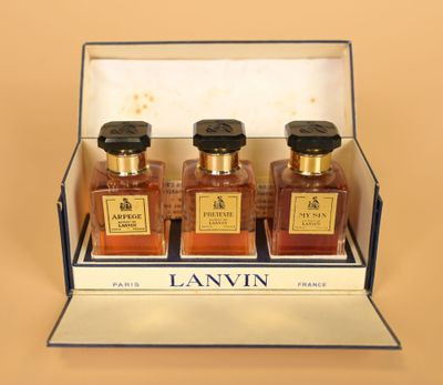 three bottles of lanvin in a display case on a table