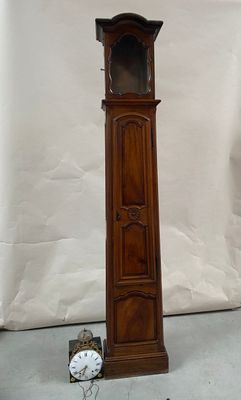 a tall wooden grandfather clock next to a small clock on the floor