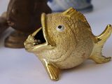a gold fish figurine sitting on a white table