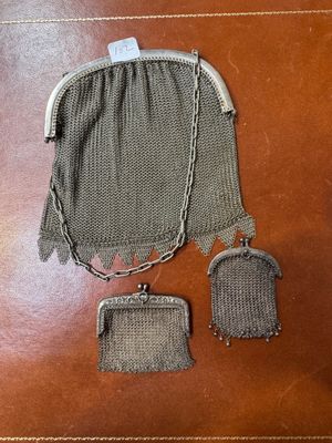 an old purse with a chain around it sitting on top of a table