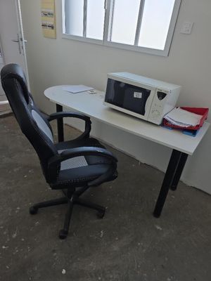 un bureau d'ordinateur sur lequel est posé un micro-ondes