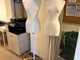 deux mannequins posés sur un socle dans une pièce