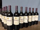several bottles of wine are lined up on a wooden table