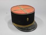 a small black hat with a gold cross on it