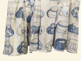 une photo d'un rideau orné de tasses à thé bleues et blanches