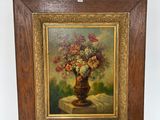 un tableau représentant des fleurs dans un vase, posé sur un chevalet