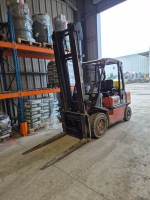 a forklift in a warehouse with pallets on the floor