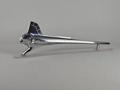un objet argenté en forme d'avion posé sur une surface blanche
