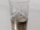 a shot glass sitting on a table with a small amount of water in it