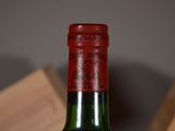 a bottle of wine sitting on a table next to a block of wood