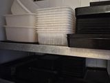 many plates and pans stacked on a shelf in a kitchen