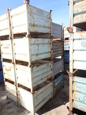 a stack of crates sitting in the dirt next to each other
