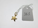 un petit pendentif en forme d'étoile en or sur lequel est accrochée une étiquette de prix