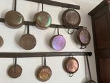 many pots and pans hanging on the wall