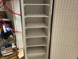 an open refrigerator sitting on the floor in a room