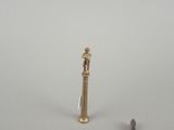 a small statue of a man standing next to a pair of screws