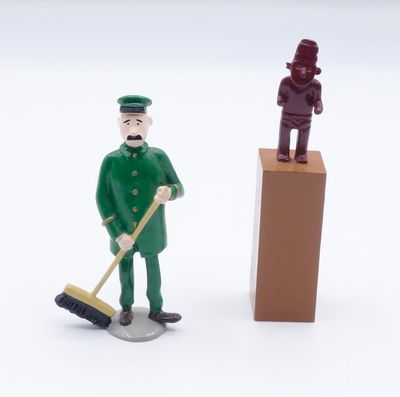 two figurines of a man with a broom and a man with a mop