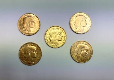 quatre types différents de pièces d'or sur une surface blanche