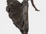 bronze statue of a woman dancing on a marble base