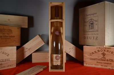 une bouteille de vin dans un coffret en bois, à côté d'autres coffrets