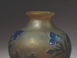 a vase with a blue flower on it sitting on a table