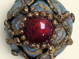 an image of a ring with a red stone in it
