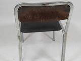 the back of a metal and leather chair with a black seat