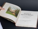 quelqu'un tient un livre dans lequel figure l'image d'une maison