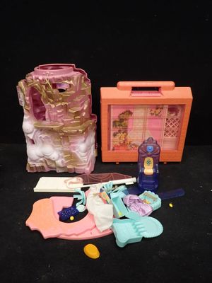 une petite maison de poupées avec une valise rose et d'autres objets