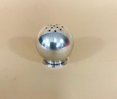 une salière et une poivrière en argent posées sur une table