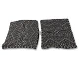a pair of black and white patterned pillows on a white background