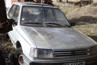 a silver car that is parked in the dirt