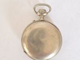 a small silver pocket watch on a white surface