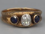 an image of a gold ring with a diamond and blue sapphires
