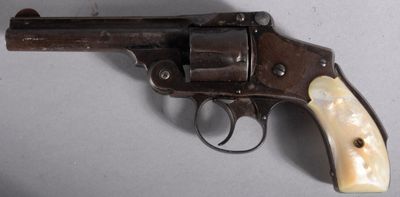 a close up of a revolver with a wooden handle on a table