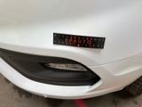 a close up of a white car with a sticker on it