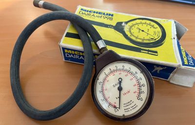 un manomètre posé sur une table à côté d'une boîte
