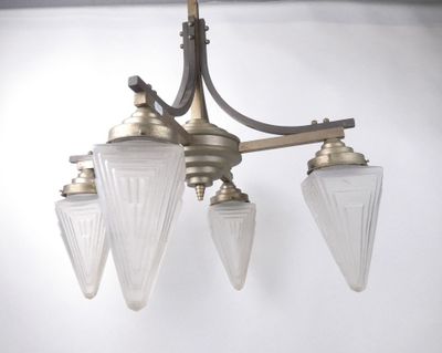 a chandelier with three glass shades hanging from the ceiling