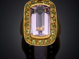 a gold ring with an amethorate and peridots