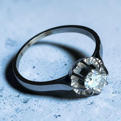 une bague sertie d'un diamant, posée sur une table